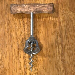 Antique corkscrew. Wood handle and metal screw and cover. Barware decor